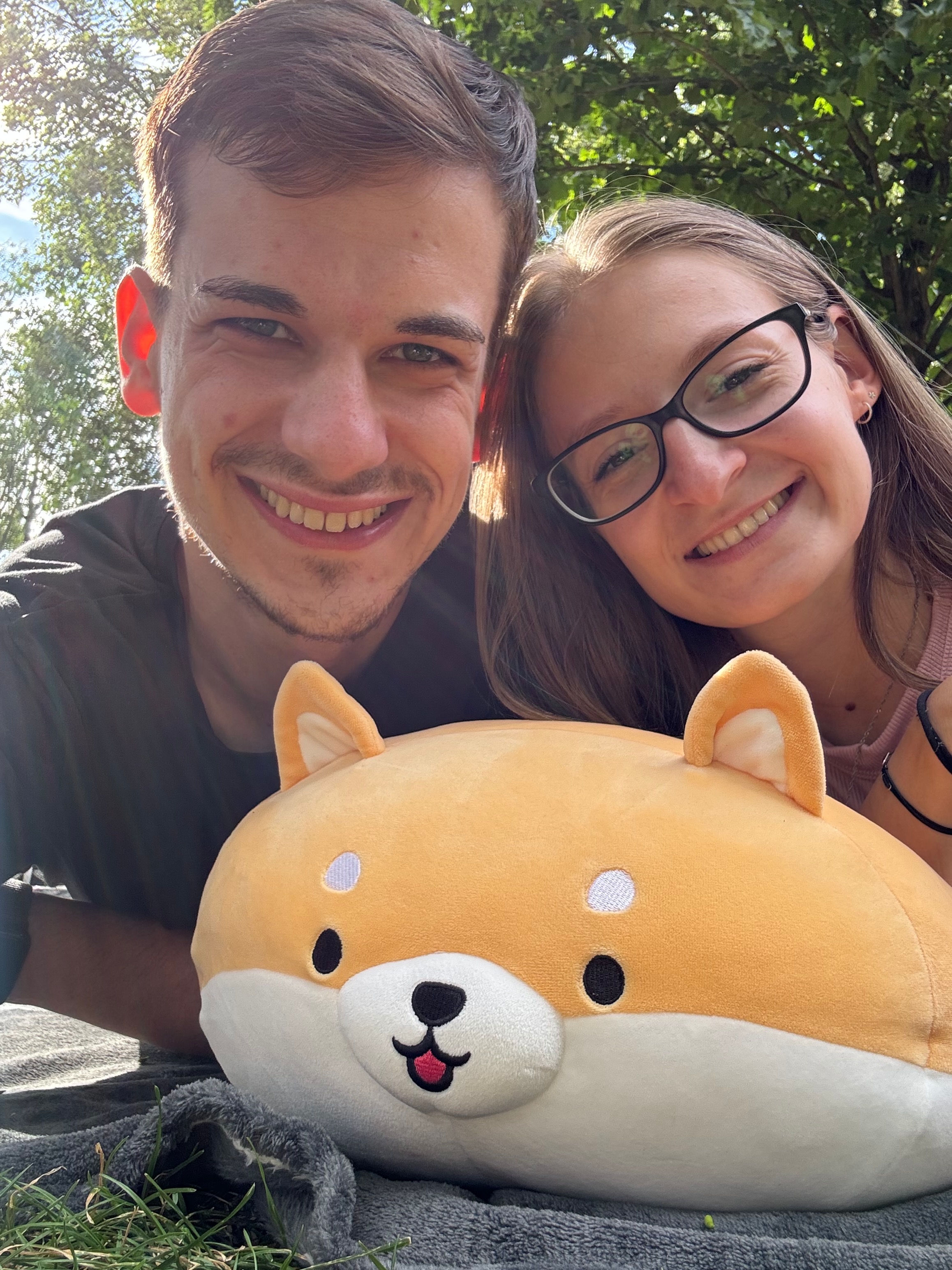 Noémi és Ádám egy plüsskutyával a szabadban